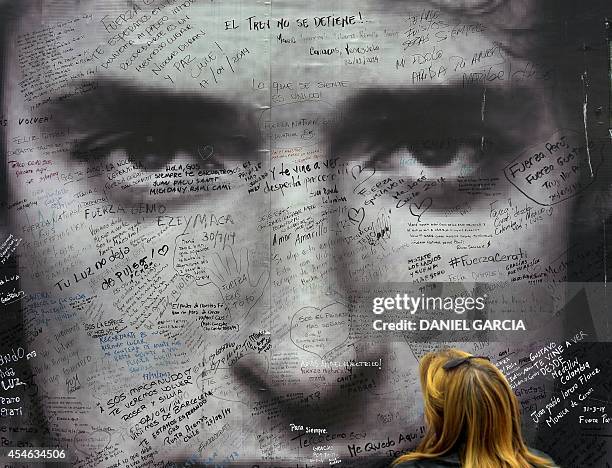 Fan watches a poster of Argentine artist Gustavo Cerati in front of the clinic where the musician died from a stroke on September 4, 2014 in Buenos...