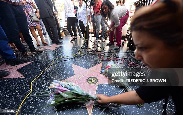 Flowers placed on the Hollywood Walk of Fame Star for Joan Rivers are re-arranged as onlookers and the media gather in Hollywood on September 4...