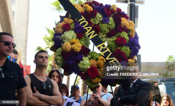 Onlookers gather beside a wreath of flowers placed on the Hollywood Walk of Fame Star for Joan Rivers in Hollywood, California on September 4...