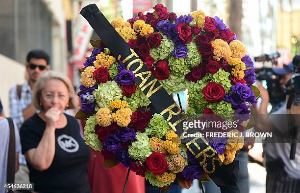 Onlookers gather beside a wreath of flowers placed on the Hollywood Walk of Fame Star for Joan Rivers in Hollywood, California on September 4...