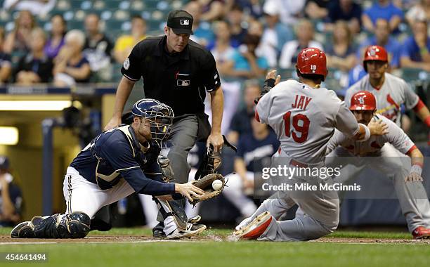 Jonathan Lucroy of the Milwaukee Brewers is late with the tag as Jon Jay of the St. Louis Cardinals slides into home plate in the top of the first...