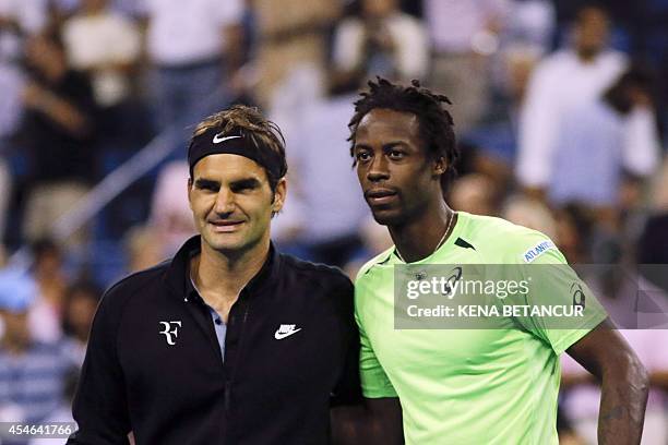 Gael Monfils of France and Roger Federer of Switzerland pose for a picture before their 2014 US Open Men's Singles Quarterfinals match at the USTA...