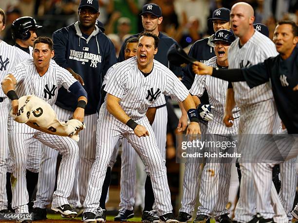 Jacoby Ellsbury, Mark Teixeira, Brian McCann and the rest of the of the New York Yankees wait for Chase Headley after his walk off home run in the...