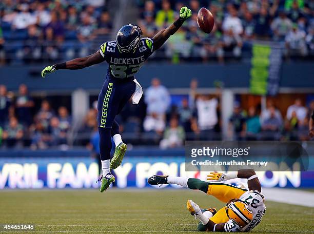 Wide receiver Ricardo Lockette of the Seattle Seahawks goes up in attempt to catch a pass as cornerback Sam Shields of the Green Bay Packers falls to...