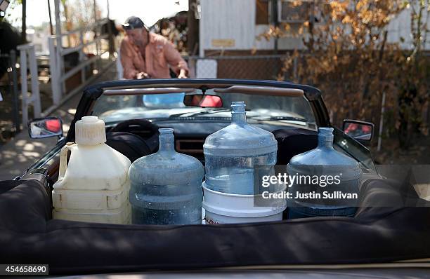 Water bottles to filled with non-potable water sit in the back seat of JC Coates' car on September 4, 2014 in Porterville, California. More than 300...