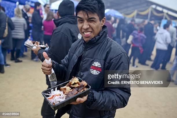 Man shows a plate of food at the gastronomic fair of Mistura, the largest in Latin America, which opened doors next to the Pacific Ocean in Lima on...