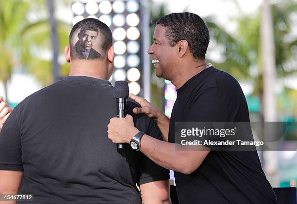 Denzel Washington admires the hair art portrait of himself on a fan's head on the set of Despierta America to promote film The Equalizer at...