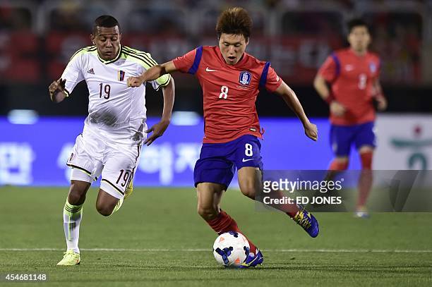 Edjar Jimenez of Venezuela chases Lee Myoung-Joo of South Korea for the ball during their friendly football match in Bucheon on September 5, 2014....