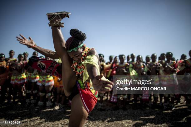 South African maiden dances as others clap during the Reed Dance ceremony on September 5, 2014 at the eNyokeni Royal Palace in Nongoma in the...