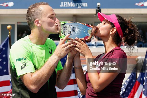 Sania Mirza of India and Bruno Soares of Brazil celebrate by kissing the trophy after defeating Santiago Gonzalez of Mexico and Abigail Spears of the...