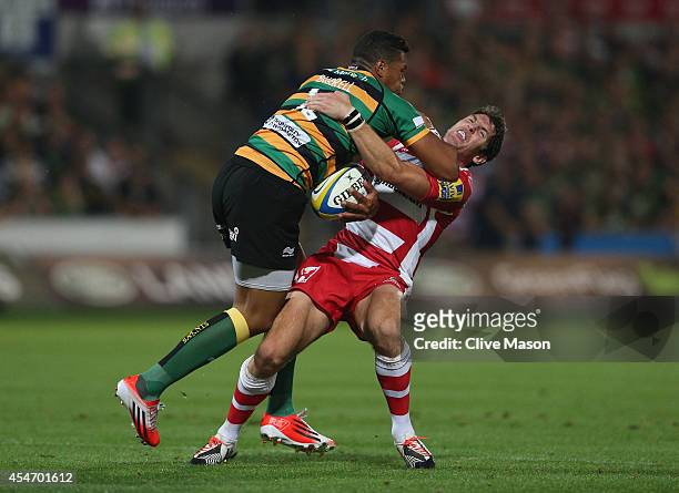 Luther Burrell of Northampton drives through James Hook of Gloucester during the Aviva Premiership match between Northampton Saints and Gloucester...