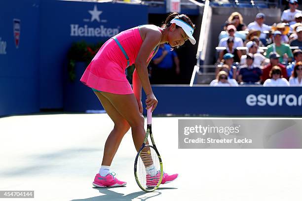 Shuai Peng of China grabs her leg after a play against Caroline Wozniacki of Denmark during their women's singles semifinal match on Day Twelve of...