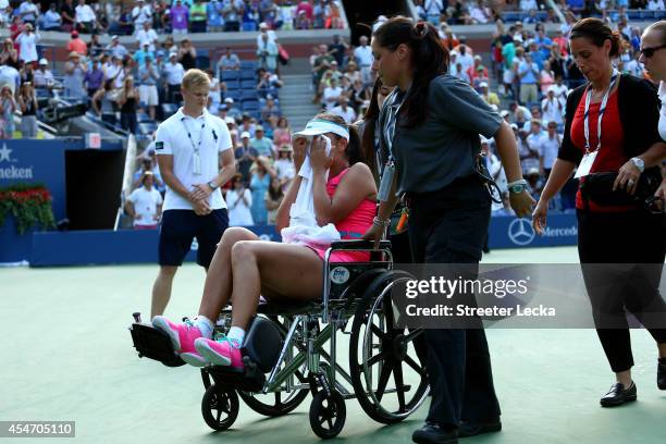 Shuai Peng of China is taken off the court by wheelchair after withdrawing from her women's singles semifinal match against Caroline Wozniacki of...