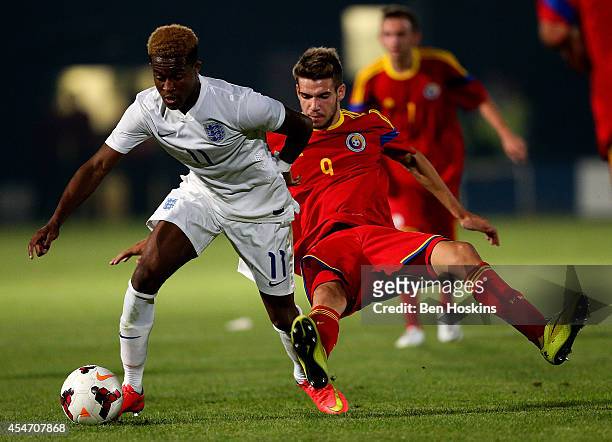 Rolando Aarons of Engand holds off pressure from Alexandru Tudorie of Romania during the U20 International friendly match between England and Romania...