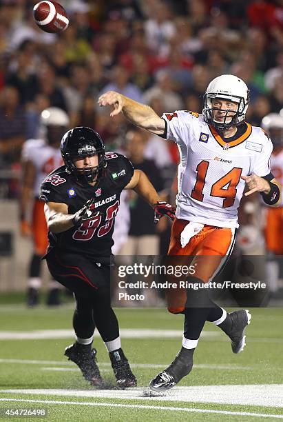 Travis Lulay of the BC Lions throws a pass with pressure coming from Justin Capicciotti of the Ottawa Redblacks during a CFL game at TD Place Stadium...