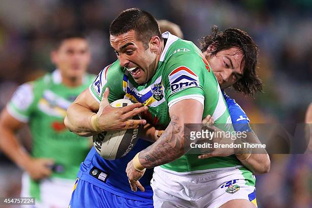 Paul Vaughan of the Raiders is tackled by Tepai Moeroa of the Eels during the round 26 NRL match between the Canberra Raiders and the Parramatta Eels...