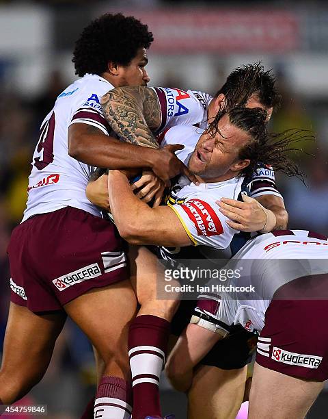Ashton Sims of the Cowboys is wrapped up by the Sea Eagle defence during the round 26 NRL match between the North Queensland Cowboys and the Manly...