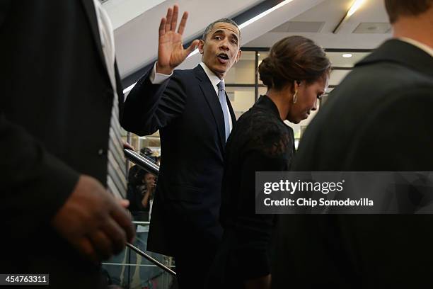 President Barack Obama and first lady Michelle Obama leave the official memorial service for former South African President Nelson Mandela at FNB...