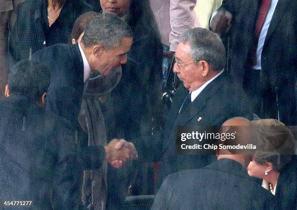 President Barack Obama shakes hands with Cuban President Raul Castro during the official memorial service for former South African President Nelson...