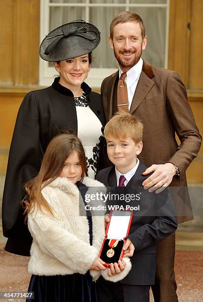 Sir Bradley Wiggins CBE poses with his wife Catherine and children Isabella and Ben after he was awarded a Knighthood by Queen Elizabeth II at an...