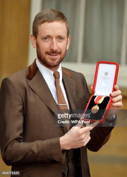 Sir Bradley Wiggins CBE holds his Knighthood award after it was presented to him by Queen Elizabeth II at an Investiture ceremony at Buckingham...
