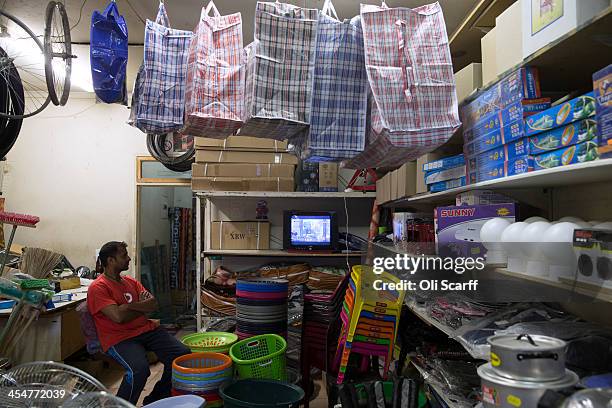 Man watches the official memorial service for Nelson Mandela on a television inside his shop 'Chipile Store', in Alexandra Township on December 10,...