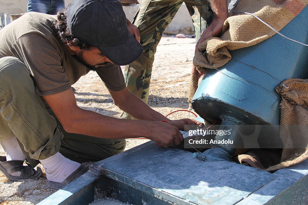 Members of Syrian Islamic Front preparing shell to hit Assad forces