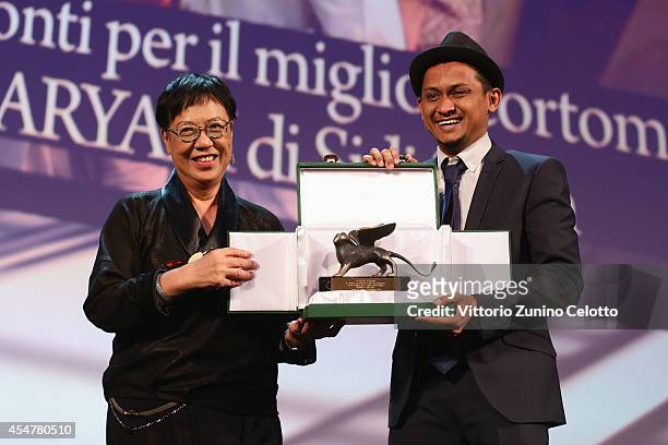 Director Sidi Saleh poses with his Orizzonti Award for Best Short Film for Maryam with Orizzonti Jury President Ann Hui on stage during the Closing...