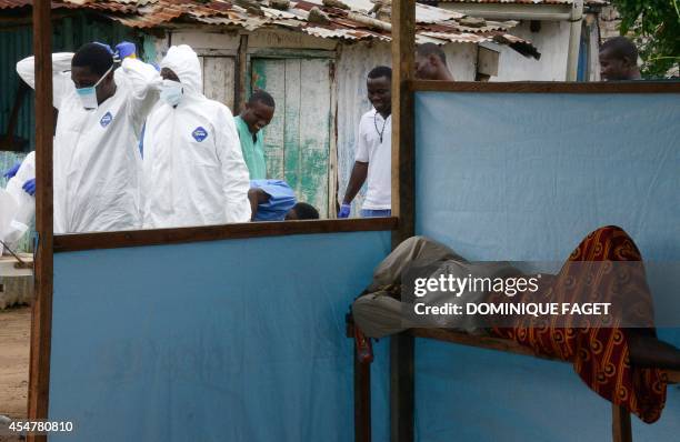 Medical workers of the John Fitzgerald Kennedy hospital in Monrovia, responsible for transport of the bodies of Ebola virus victims, wear their...