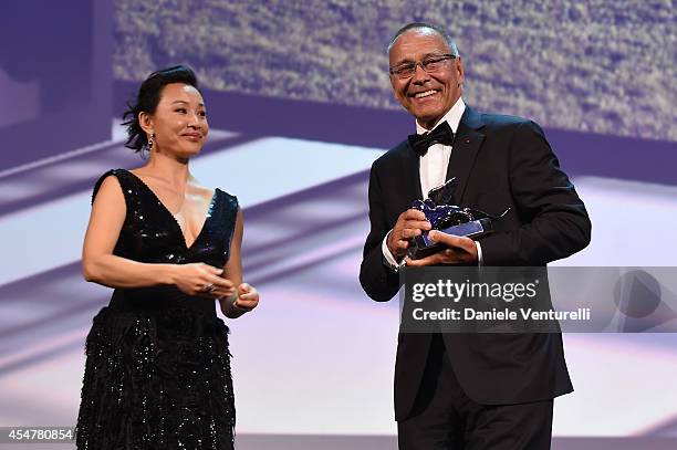 Director Andrey Konchalovskiy poses onstage with Jury member Joan Chen with the Silver Lion for Best Director he received for his movie 'The...