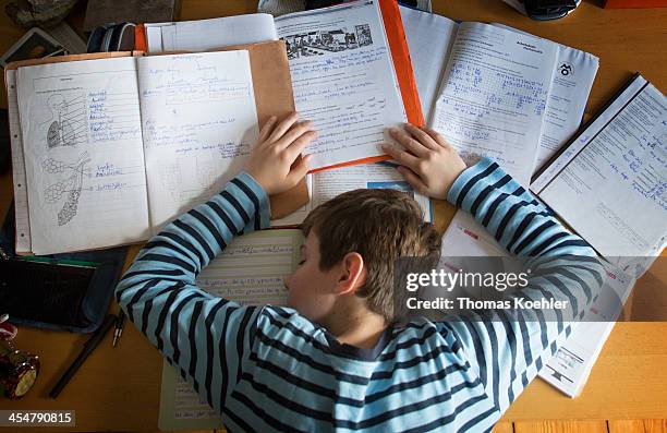 Staged photo of a boy having fallen asleep at his desk whilst doing homework as pictured on October 27, 2013 in Berlin, Germany.