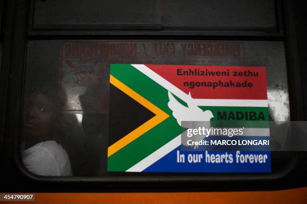 Woman sits inside a bus that will take her home after she attended the memorial service for late South African President Nelson Mandela at Soccer...