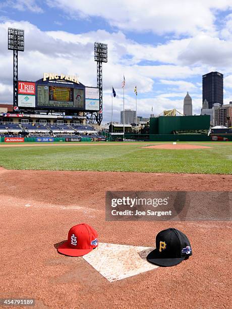 Detail shot of the Pittsburgh Pirates and St. Louis Cardinals caps sit on homeplate prior to Game Four of the National League Division Series on...