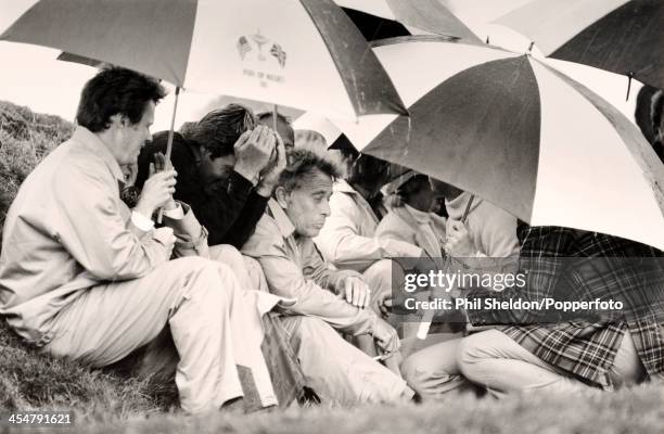 Some of the United States team, from left to right, Tom Watson with his wife Linda, Ben Crenshaw and David Marr sheltering from the rain during the...