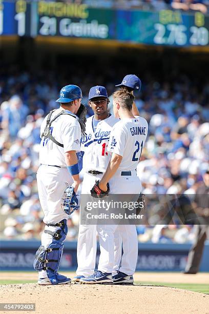 Zack Greinke of the Los Angeles Dodgers meets on the mound with A. J. Ellis and Hanley Ramirez during Game Five of the National League Championship...