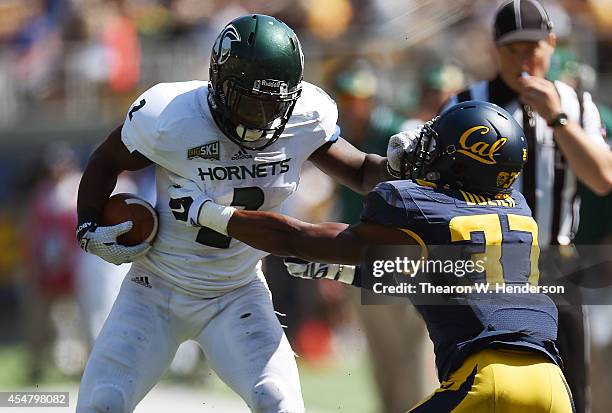 DeAndre Carter of the Sacramento State Hornets pushes off the tackle of Cedric Dozier of the California Golden Bears during the third quarter of an...