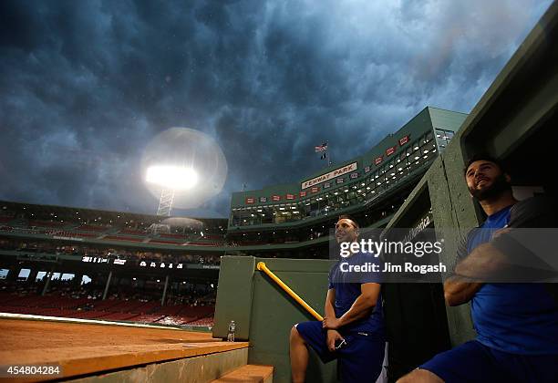 George Kottaras and Brandon Morrow of the Toronto Blue Jays watch the weather over Fenway Park before a game between the Toronto Blue Jays and Boston...