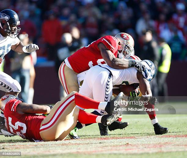 NaVorro Bowman, Ahmad Brooks and Donte Whitner of the San Francisco 49ers tackle Robert Turbin of the Seattle Seahawks during the game at Candlestick...