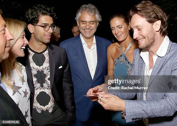 Amos Bocelli, Andrea Bocelli, and Veronica Berti watch the Mentalist Lior Suchard perform during an exclusive dinner at the Casa Cavalli estate...