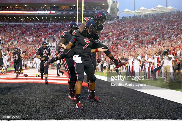 Reggie Bonnafon of the Louisville Cardinals celebrates with teammates after scoring a touchdown during the game against the Murray State Racers at...