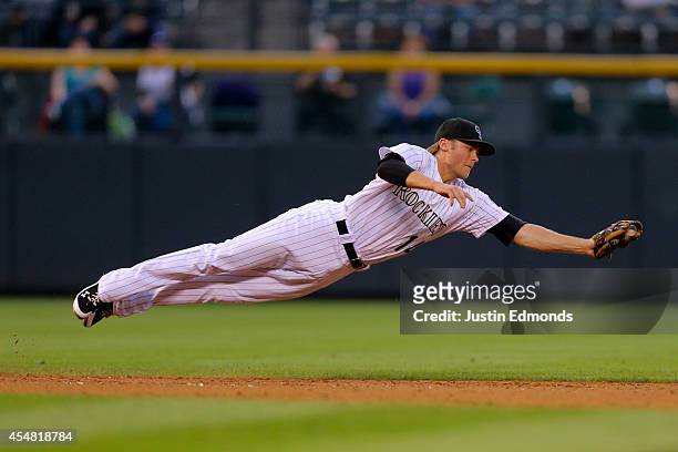 Shortstop Josh Rutledge of the Colorado Rockies makes a diving catch for the first out of the third inning against the San Diego Padres at Coors...