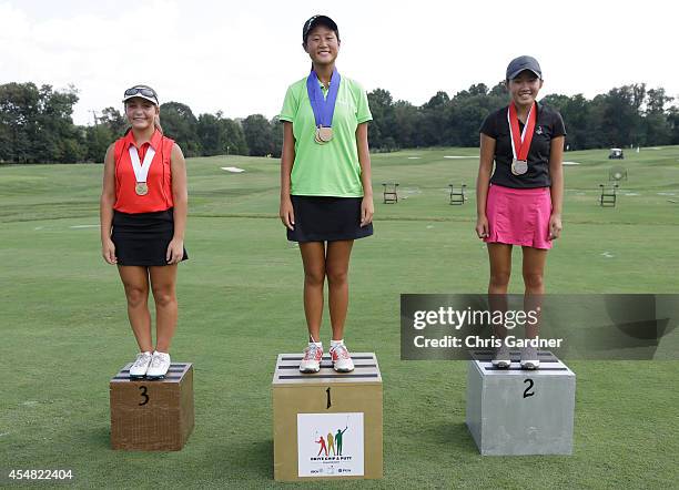 Gina Kim, center, of Chapel Hill, NC, is joined on the podium by second place finisher Ashley Nguyen of South Riding, VA, right, and Sofia Amoroso,...