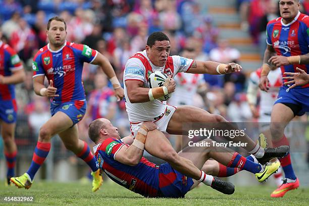 Tyson Frizell of the Dragons is tackled by the Knights defence during the round 26 NRL match between the Newcastle Knights and the St George...