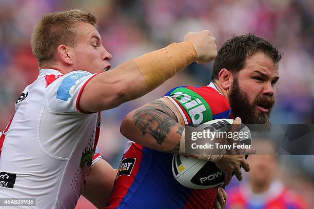 Adam Cuthbertson of the Knights is tackled by the Dragons defence during the round 26 NRL match between the Newcastle Knights and the St George...