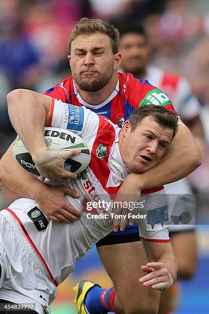 Brett Morris of the Dragons is tackled by Robbie Rochow of the Knights during the round 26 NRL match between the Newcastle Knights and the St George...