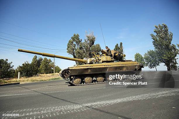 Ukrainian tank drives down a street on the outskirts of the strategic coastal city of Mariupol following an evening of heavy shelling by Russian...