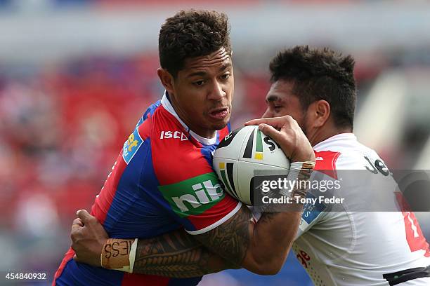 Dane Gagai of the Knights is tackled by Peter Mata'Utia of the Dragons during the round 26 NRL match between the Newcastle Knights and the St George...