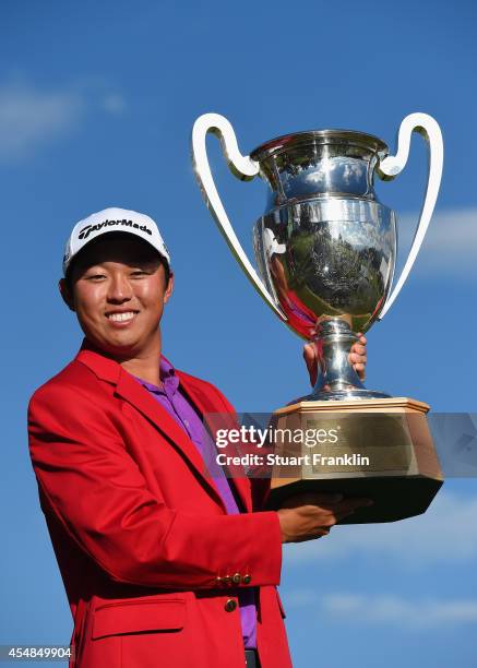 David Lipsky of USA holds the winners trophy after winning in a playoff against Graeme Storm of England during the final round of the Omega European...