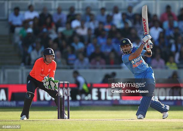 Virat Kohli of India hits out as Jos Buttler of England looks on during the NatWest International T20 2014 match between England and India at...