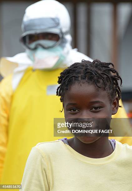 Health worker wears on September 7, 2014 a protective suit behind an Ebola-infected child inside the high-risk area of Elwa hospital in Monrovia,...